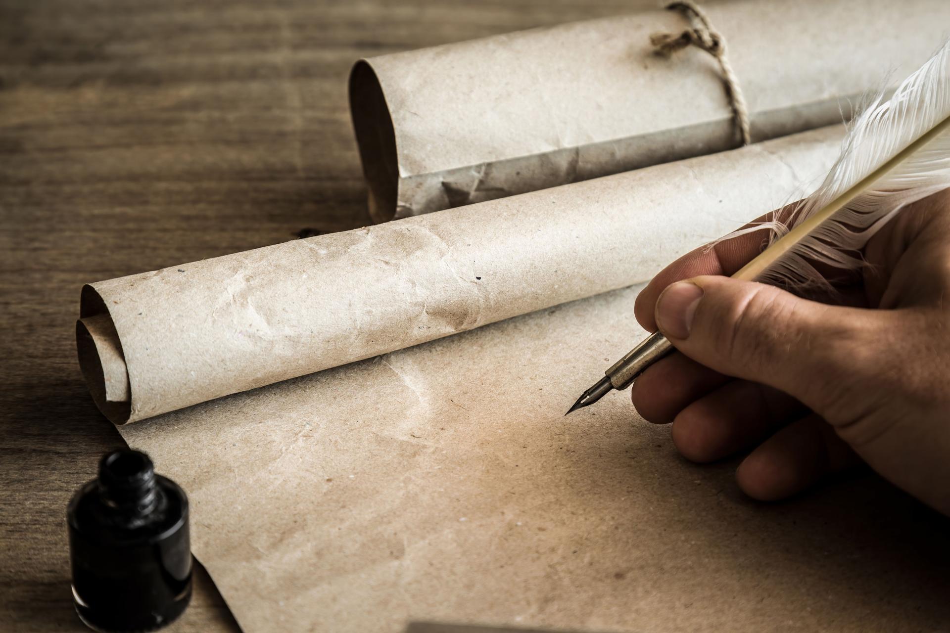 Hand writing with old quill pen on the old paper. Historical atmosphere. Empty place for a text.